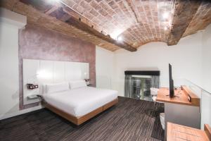 a bedroom with a bed and a desk and a fireplace at Petit Palace Boqueria Garden in Barcelona
