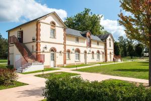 un vecchio edificio con una scala di fronte di Le Mans Country Club a Yvré-lʼÉvêque