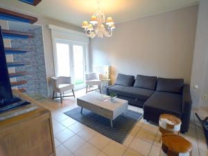 a living room with a couch and a table at Family home with pond and terrace in Le Bizet