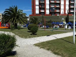 a park with a palm tree and a building at San Clemente Aventura in San Clemente del Tuyú