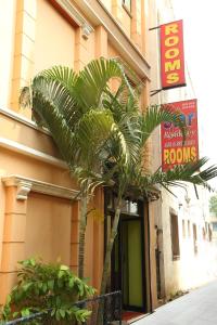 a palm tree in front of a building with a sign at Star Residency in Chennai