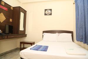 een slaapkamer met een bed, een spiegel en een tv bij Star Residency in Chennai