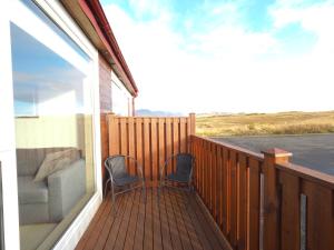 een balkon met 2 stoelen en een bank erop bij Hotel Laxarbakki in Leirá