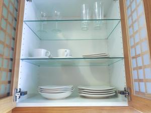 a glass cabinet with plates and cups in it at Hotel Laxarbakki in Leirá