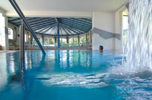 a woman in a swimming pool with a fountain at Hotel Badischer Hof in Biberach bei Offenburg