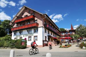 dos personas montando bicicletas en frente de un edificio en Wochner's Hotel-Sternen Am Schluchsee Hochschwarzwald en Schluchsee