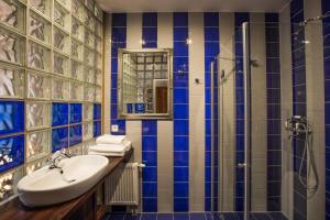 a blue and white bathroom with a sink and a shower at Retro hotel Garage in Ostrava