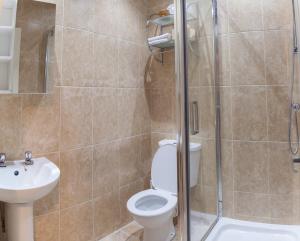 a bathroom with a toilet and a sink and a shower at The Trafford Hotel in Blackpool +67 photos