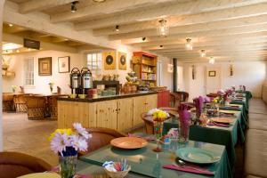 a restaurant with a long table with flowers on it at Las Palomas in Santa Fe