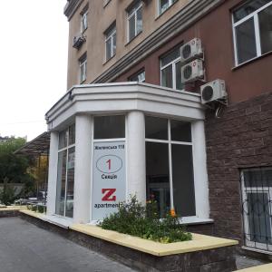 Una tienda frente a un edificio con un reloj. en The apartments en Kiev