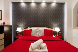 a bedroom with a red bed with two hands on it at Apartament PAJO II REZYDENCJA TATRY in Zakopane