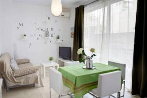 salon z zielonym stołem i białymi krzesłami w obiekcie Thelma's Apartment w Atenach