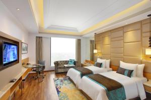 um quarto de hotel com duas camas e uma televisão de ecrã plano em Radisson Blu Jammu em Jammu