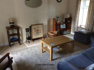 a living room with a blue couch and a coffee table at Hallmount Cottage - Belfast in Belfast
