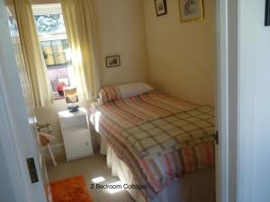 a small bedroom with a bed and a window at Hallmount Cottage - Belfast in Belfast +2 photos