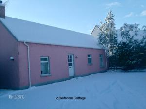 un bâtiment en briques rouges avec une cour recouverte de neige dans l'établissement Hallmount Cottage - Belfast, à Belfast