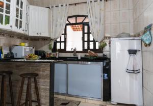 eine Küche mit einer Spüle und einem Kühlschrank in der Unterkunft Casa & Hospedagem Carol in Cachoeira Paulista