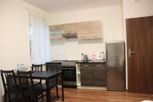 a kitchen with a table and a stainless steel refrigerator at Fredry 8 in Piastów