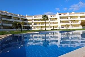 un gran edificio de apartamentos con una gran piscina en Falésia Marina - Clever Details, en Vilamoura