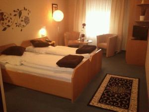 a bedroom with a large bed with two pillows on it at Hotel Restaurant Byblos in Nordwalde