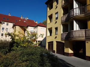 uma fila de edifícios de apartamentos com varandas numa rua em City Vendégház Mohács em Mohács