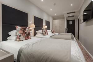 two beds in a hotel room with white walls at Blandford Hotel in London