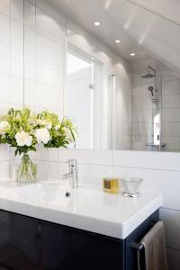 a bathroom with a sink with a vase of flowers at Wow Apartments Örgryte in Gothenburg
