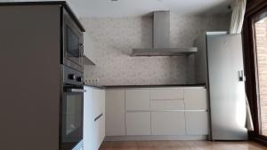 cocina con armarios blancos y microondas en Apartamento de Lujo Av. Barber en Toledo