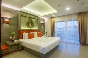 1 dormitorio con cama grande y ventana grande en Chhay Long Angkor Boutique Hotel Siem Reap, en Siem Reap