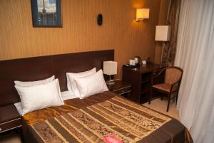 サラトフにあるBogemia City Hotelのベッドとデスクが備わるホテルルームです。