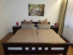 バート・ウーラッハにあるFREE Apartment - Bei den Thermenの赤いキャンドルが2つあるベッドルームのベッド1台