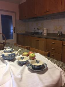 a kitchen table with plates and bowls of fruit on it at La Casa di Luigi in Montevarchi