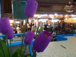 a group of purple flowers in front of a market at HuaHin Night Market Hostel in Hua Hin