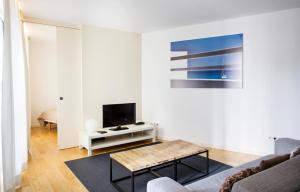 a living room with a couch and a tv at Durlet Beach Apartments in Barcelona