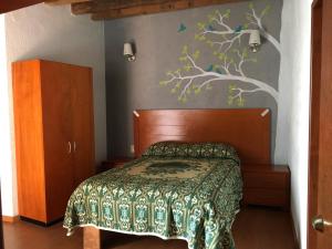 - une chambre avec un lit et une fresque murale sur les arbres dans l'établissement Hotel Terraza Castro, à Zacatecas