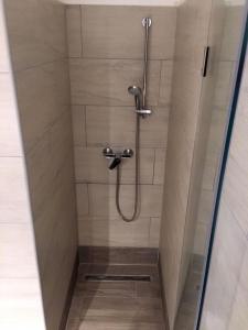 a shower with a shower head in a bathroom at Klauzál Apartman in Budapest