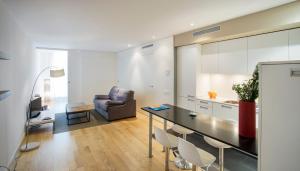 eine Küche und ein Wohnzimmer mit einem Tisch und einem Sofa in der Unterkunft Durlet Beach Apartments in Barcelona