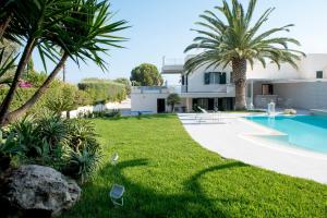 a villa with a swimming pool and palm trees at Villa Vulcano in Marina di Ragusa
