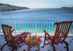 two chairs and a table in front of the ocean at Hotel Elcano in Acapulco