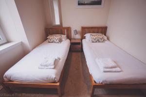 two twin beds in a room with a window at Apartment C in Aberdeen