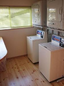 a kitchen with two washer and dryers in a room at Aso Base Backpackers in Aso