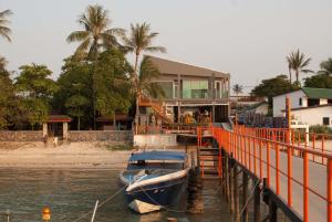 a boat is docked next to a house on the water at Marina Residence in Bang Rak Beach
