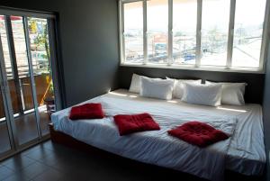 1 dormitorio con 1 cama con 2 almohadas rojas en Marina Residence, en Bangrak Beach