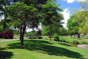 un parque con un árbol en medio de un campo en Redhouse en Salisbury