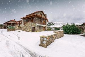 a log cabin in the snow with snow at Monte Bianco Villas in Arachova