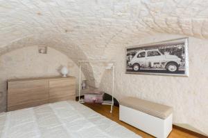 オストゥーニにあるDimora Alfonso Pomesのベッド付きのベッドルーム1室、壁に車の写真