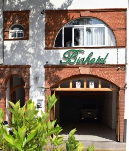 a brick building with a garage with a sign on it at Biohotel Boutique Metepec in Toluca
