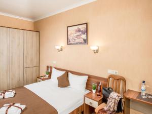 a hotel room with a bed and a desk with a chair at Hotel&SPA Pysanka, Готель Писанка, 3 сауни та джакузі - індивідуальний відпочинок у СПА in Lviv