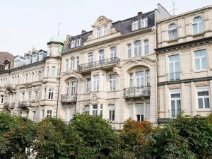 バーデン・バーデンにあるRoyal Apartment City Center Baden-Badenの目の前に木々が植えられた白い大きな建物