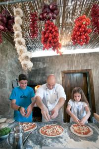 a couple of people preparing pizzas in a kitchen at Caruso, A Belmond Hotel, Amalfi Coast in Ravello